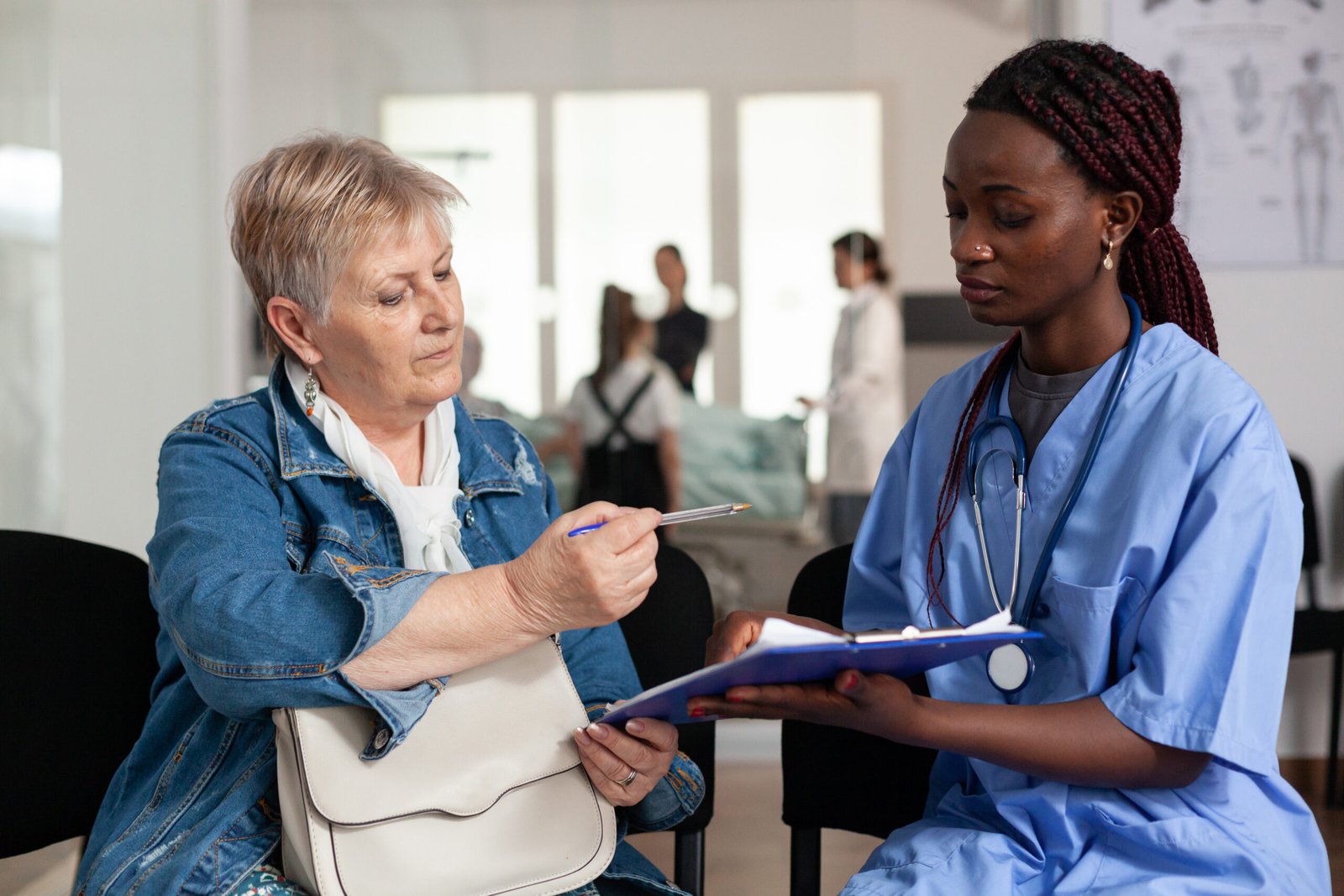 african american nurse explaining sickness treatment to elderly patient